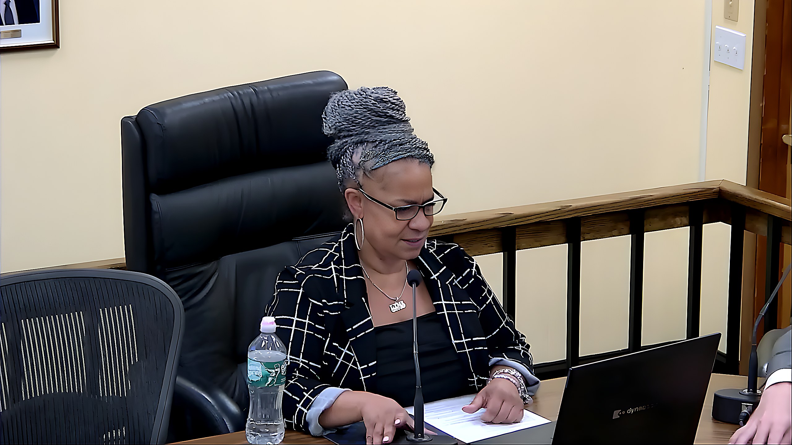 A village official reviews documents at the dais as the meeting opens with the approval of vouchers.